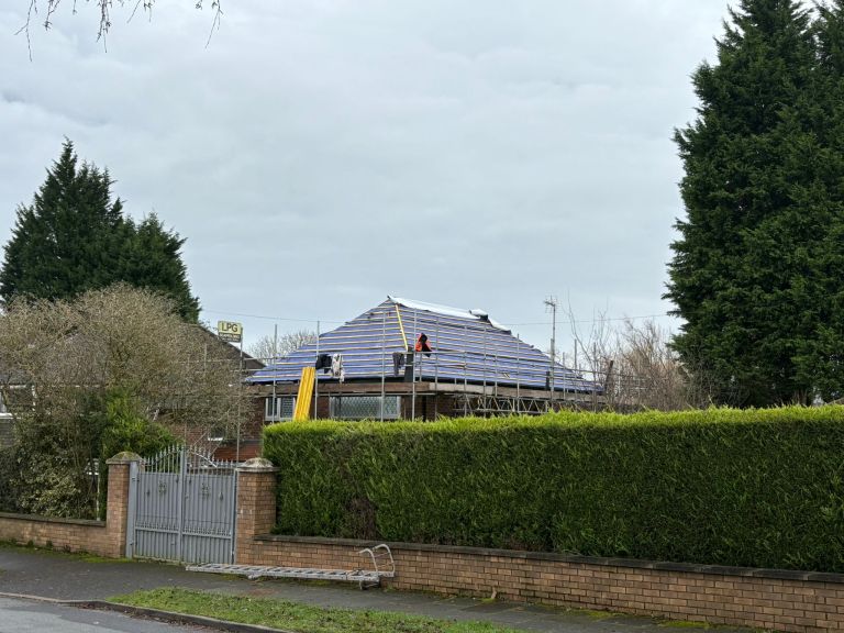 Side view of hipped roof underlay and battens during roof installation