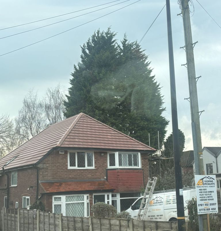 Completed red tiled hipped roof above diamond-pattern bay windows
