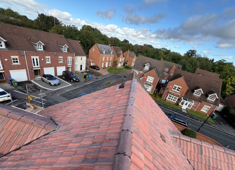Completed red tiled roof and twin dormers viewed from the ridge