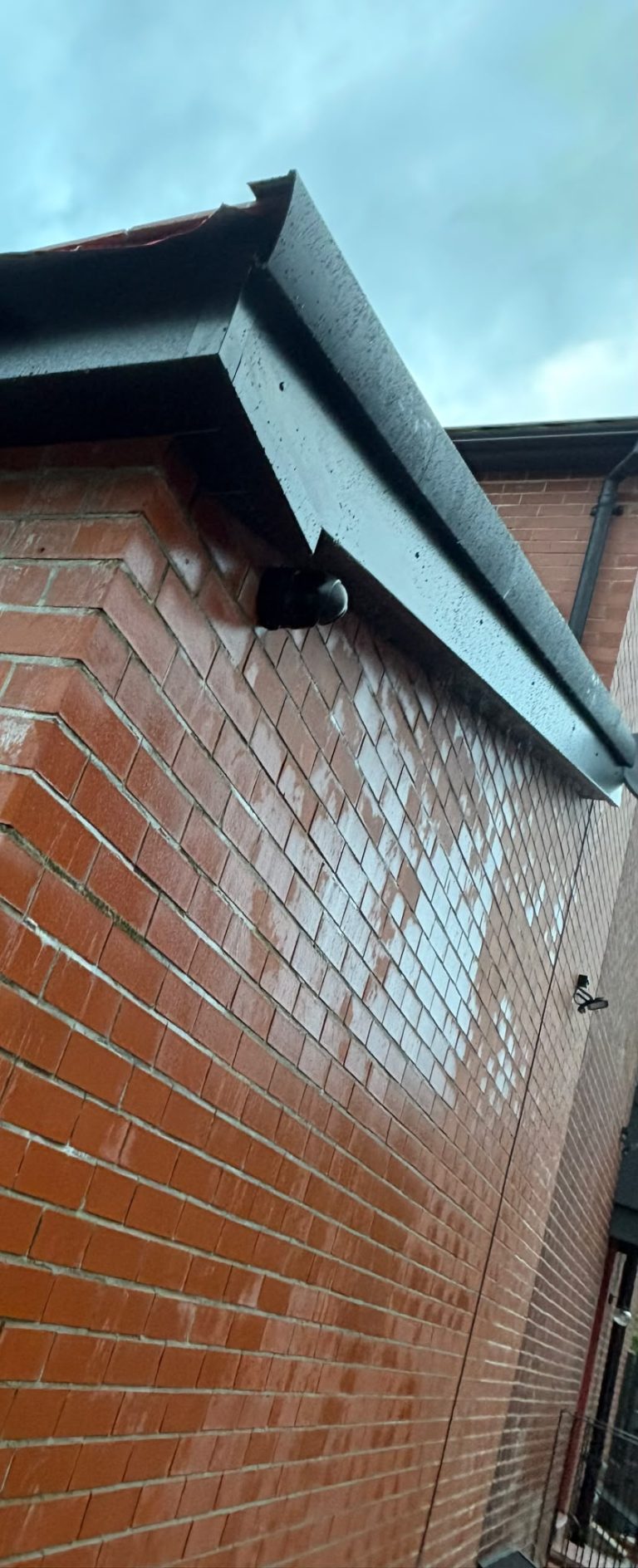 Black fascia detailing around a decorative brick gable