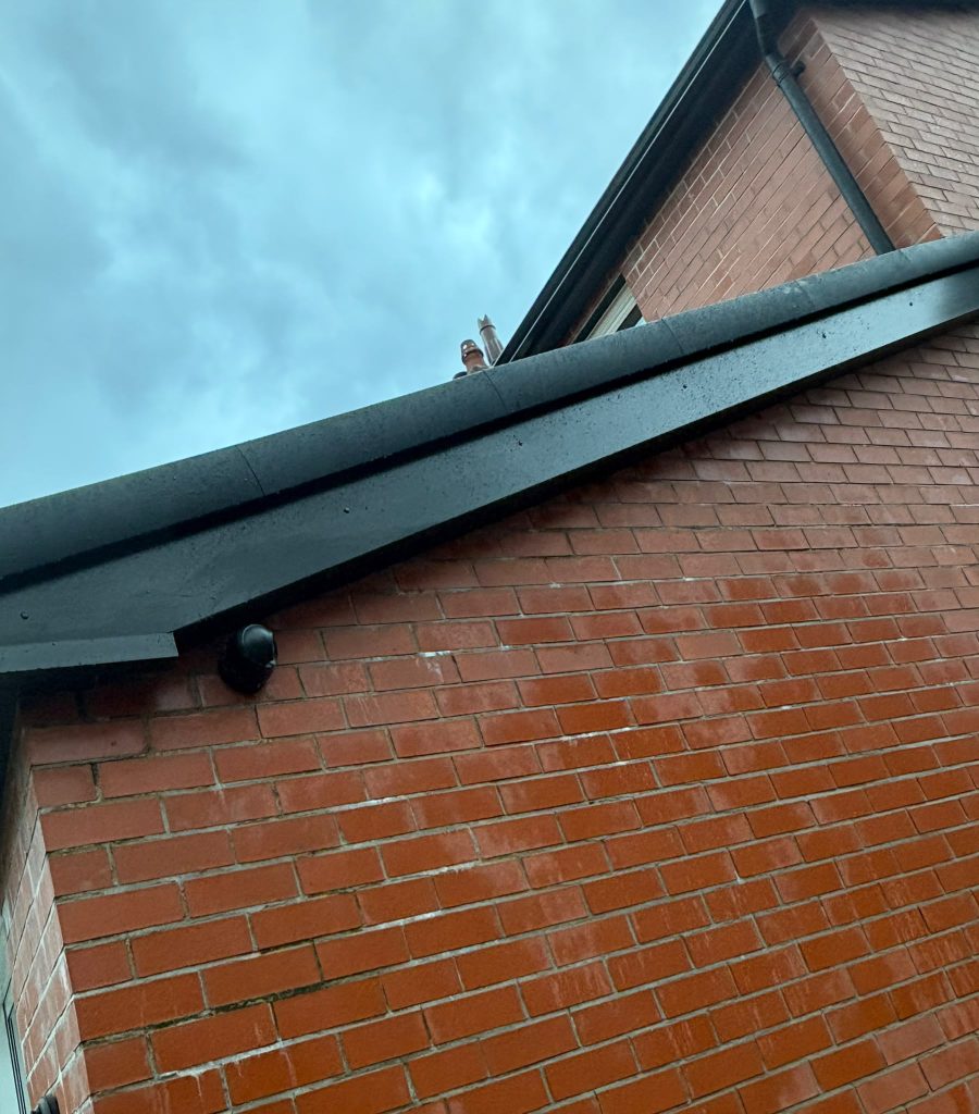 Black soffit and fascia along a decorative brick gable roofline