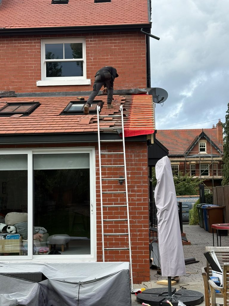 Rear roof installation in progress on a red-brick home